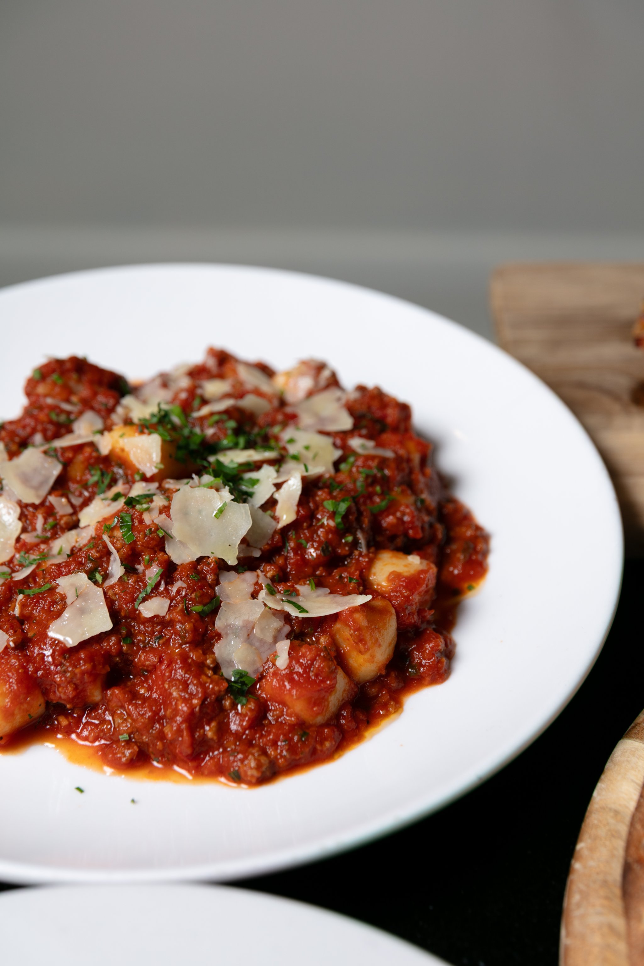 Pasta in a rich tomato sauce topped with shaved parmesan