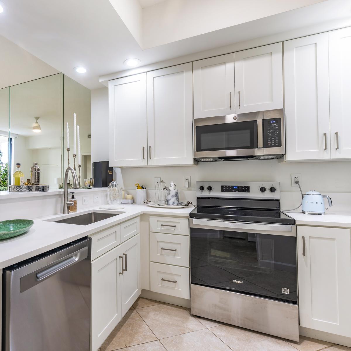 White kitchen with quartz counters and stainless steel appliances