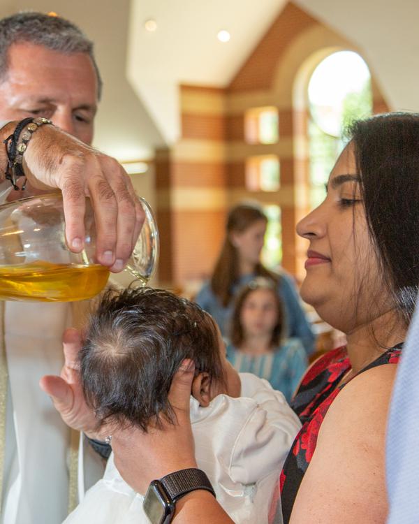 A baby being baptised as water is poured over its head