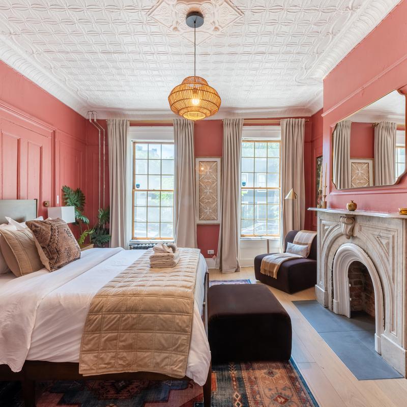 Hotel bedroom with deep red walls and a marble fireplace