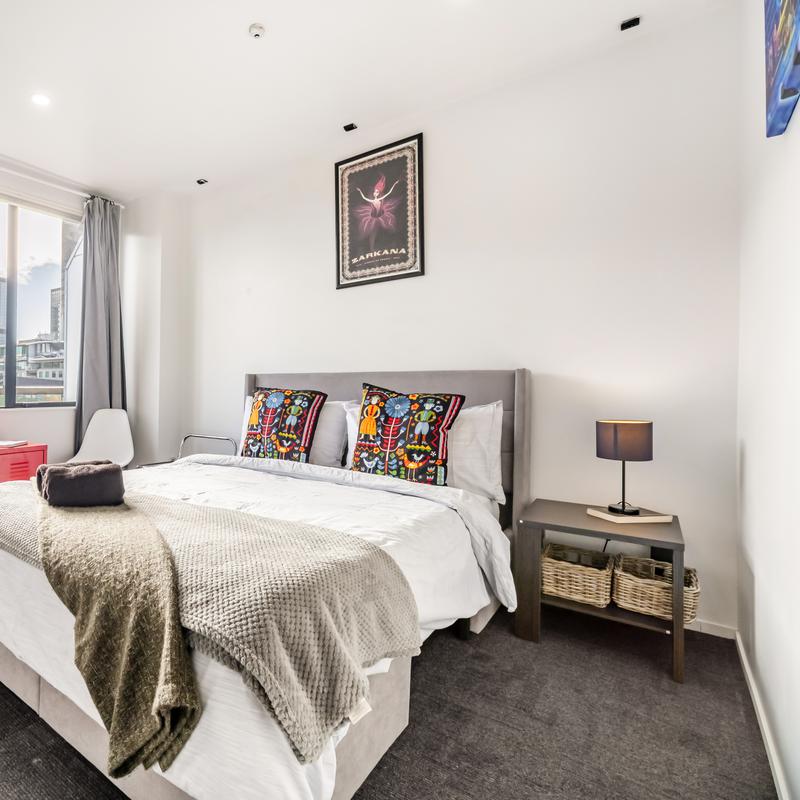 Boutique hotel bedroom with grey bed and tall window